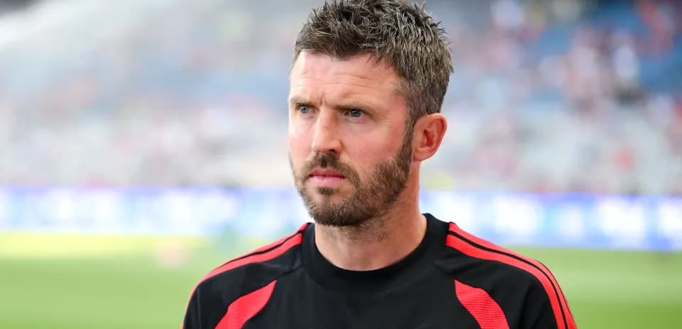 Coach wearing Manchester United training kit on pitch