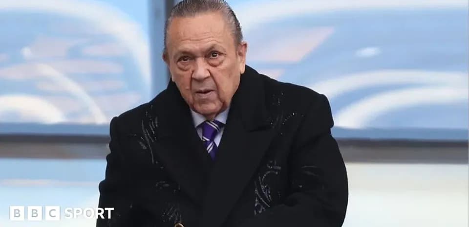 Man in a black coat at a sports event