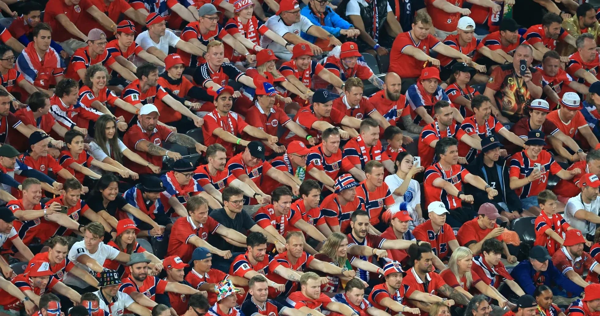 Crowd of fans in red jerseys cheering together