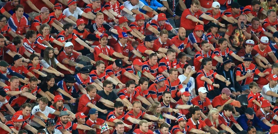 Crowd of fans in red jerseys cheering together