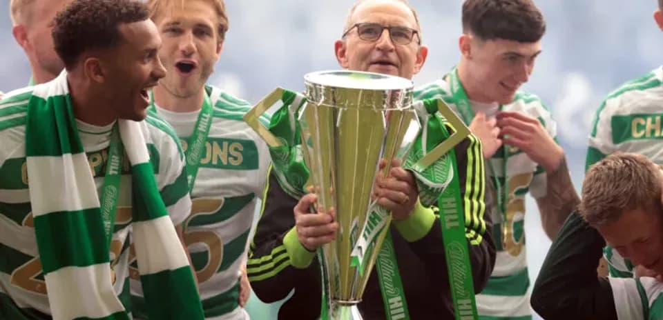 Celtic players celebrating with trophy on stage