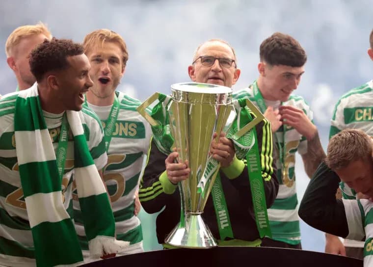 Celtic players celebrating with trophy on stage