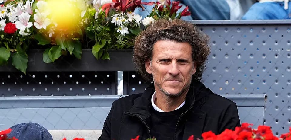 Man sitting among flowers at a tennis event