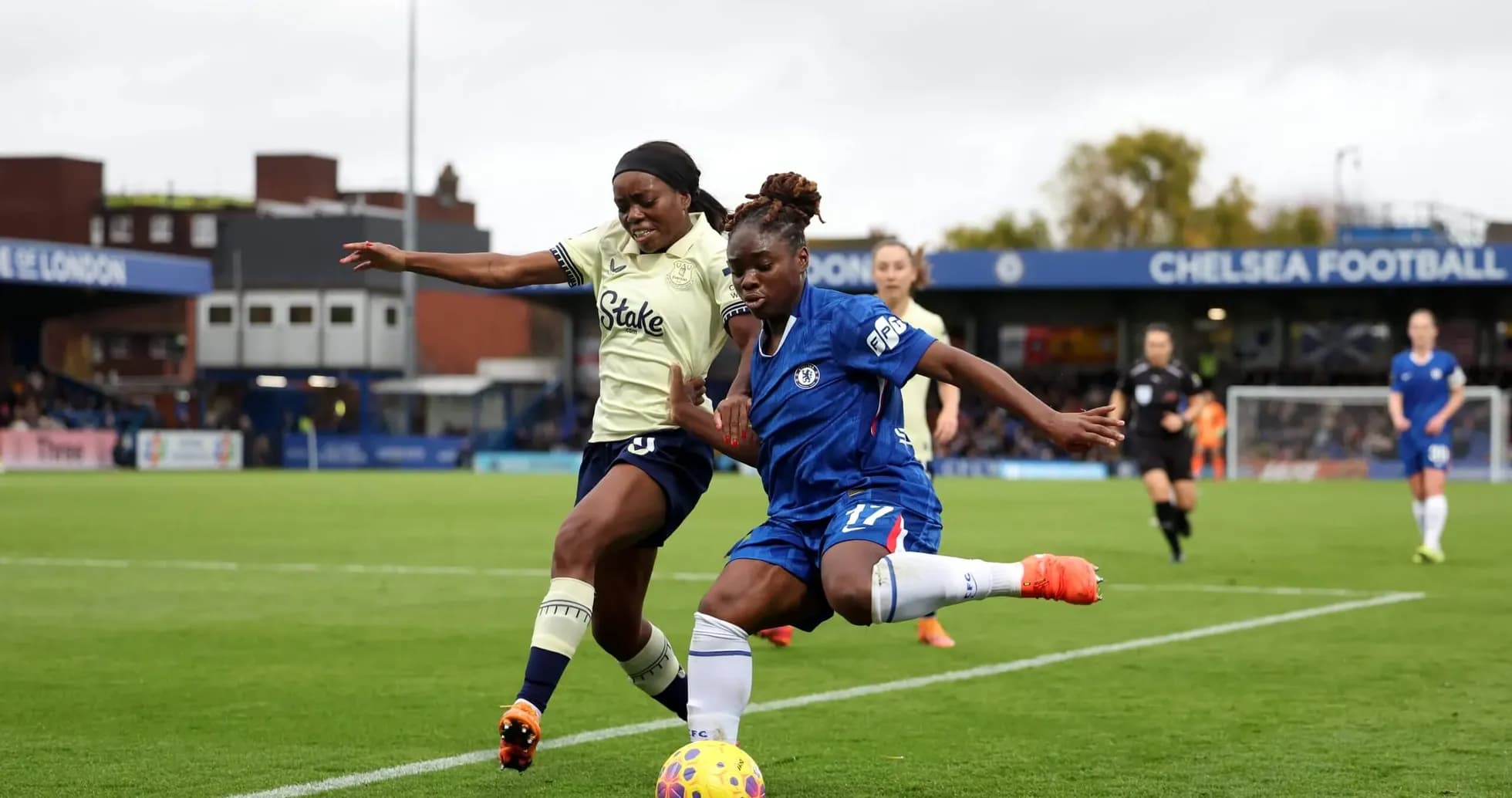 Everton W player challenges Chelsea W for the ball