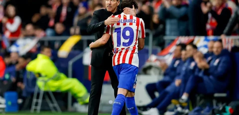 Coach embracing player on the sidelines during match