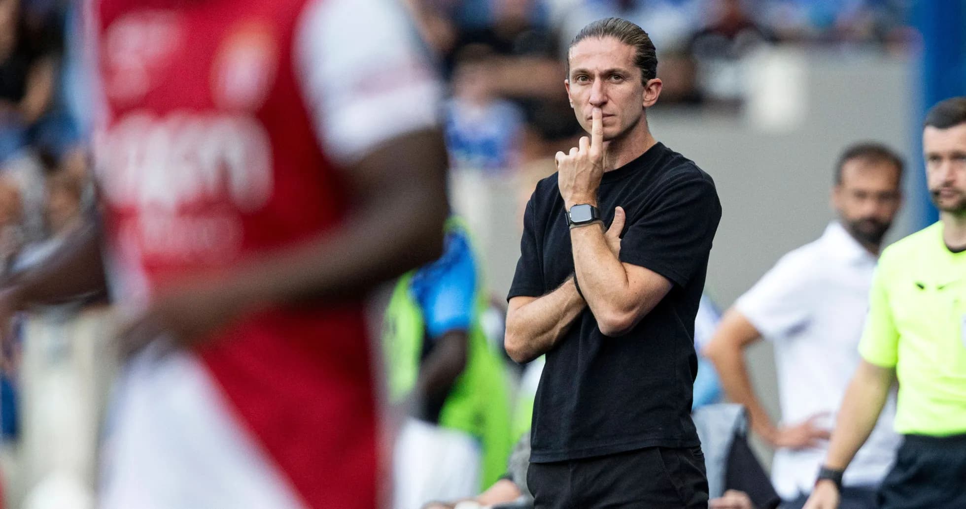 Coach observing match with a finger on lips