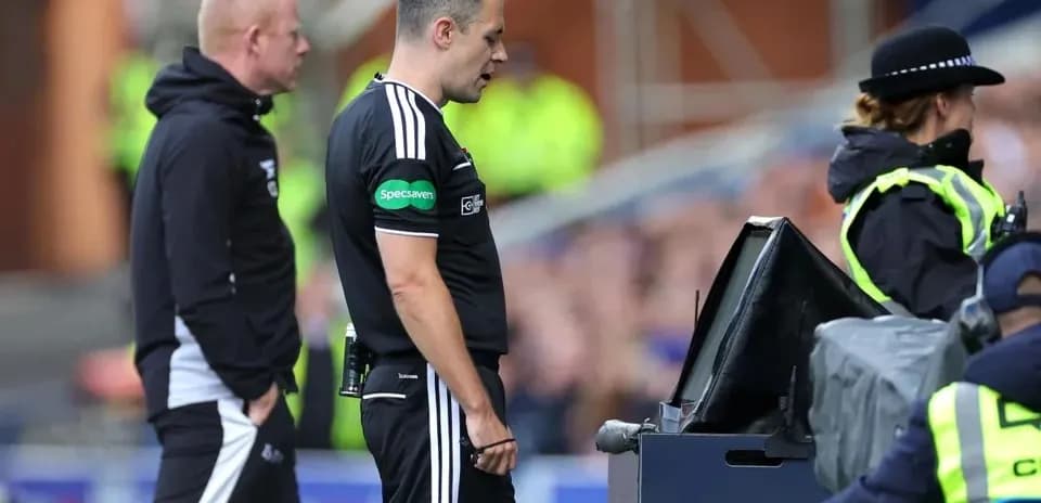 Referee consulting VAR monitor during match decision