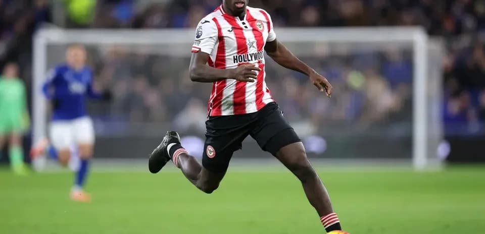 Player in red and white kit running on the pitch