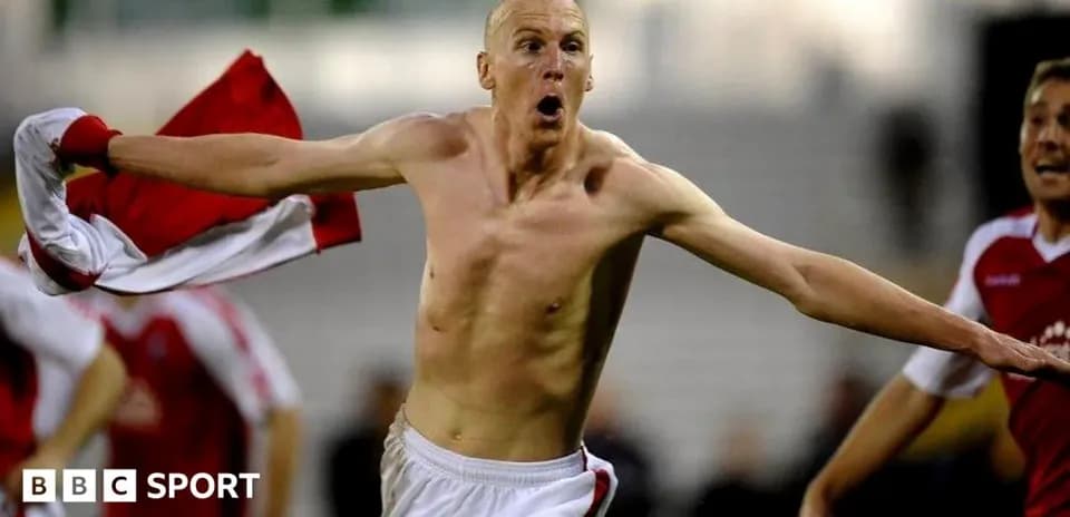 Player celebrating shirtless after scoring a goal