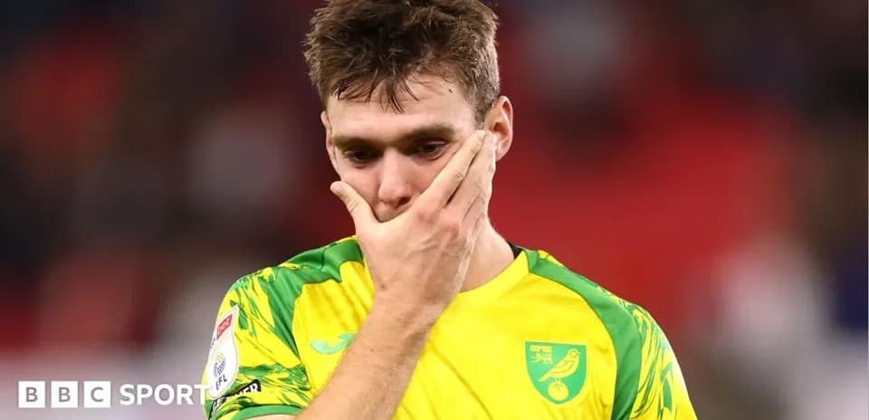 Player in Norwich City kit looking distressed on field