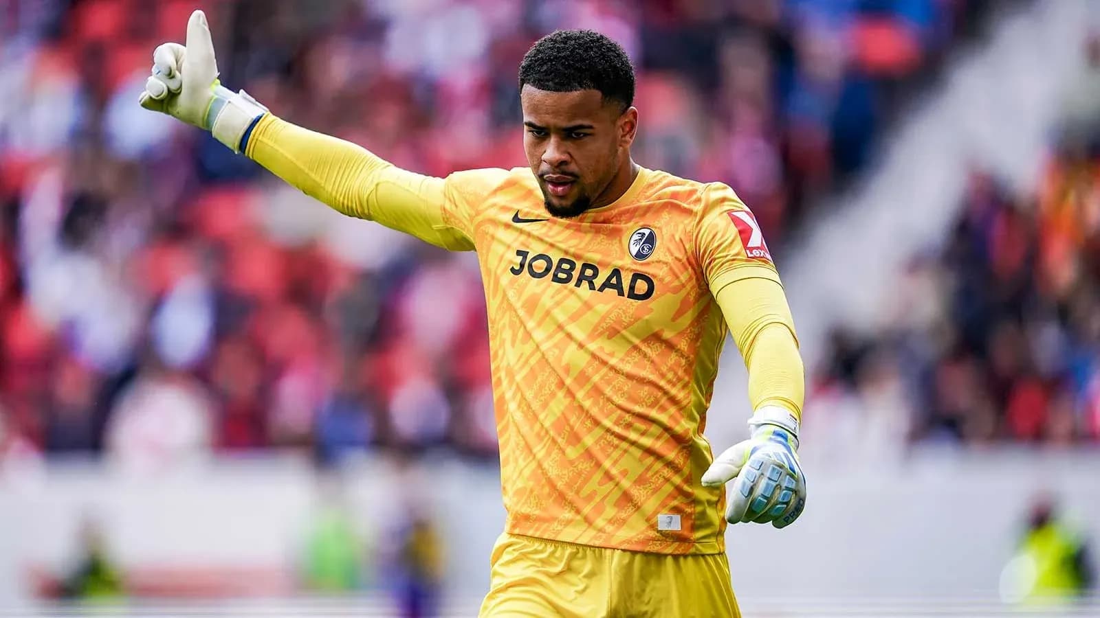 Goalkeeper gesturing during a match in yellow kit