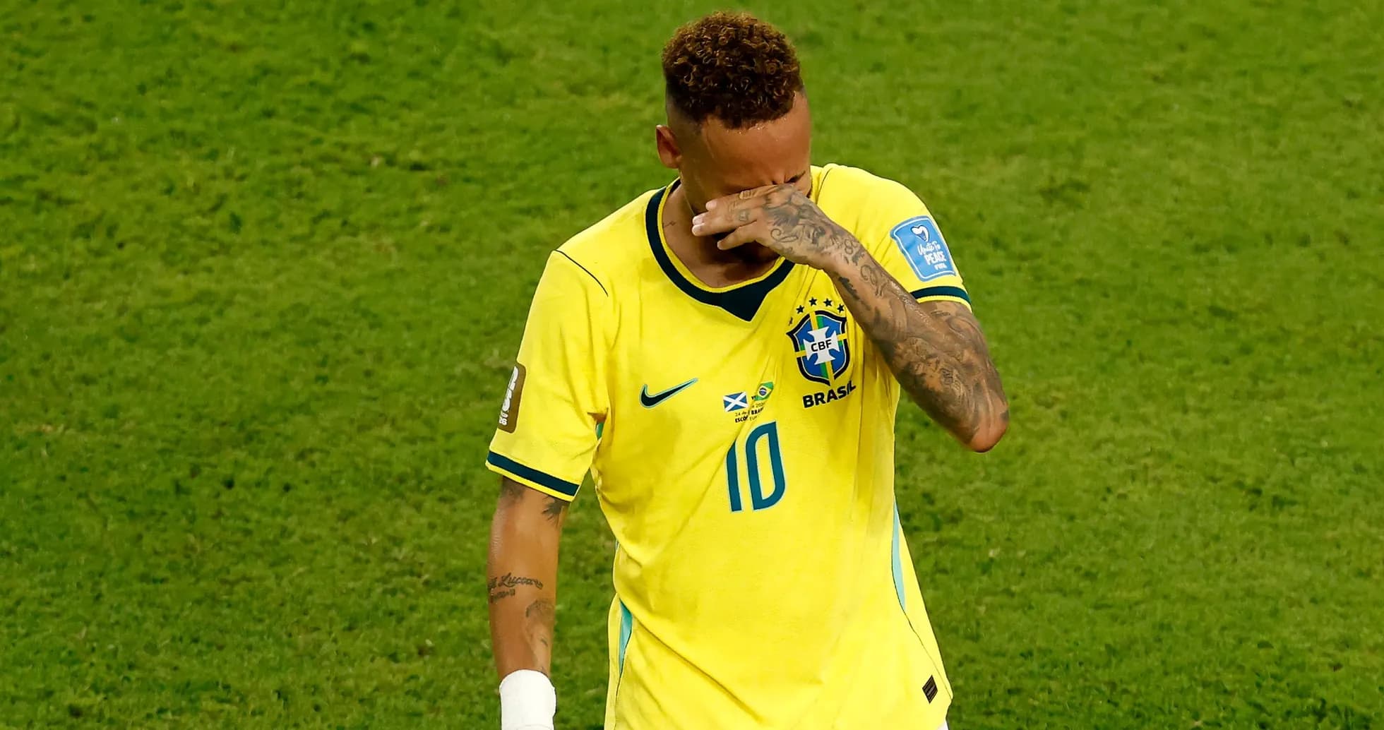 Player in Brazil jersey wipes face during match