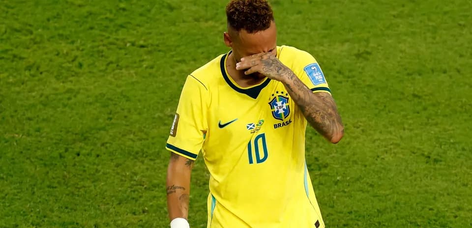 Player in Brazil jersey wipes face during match