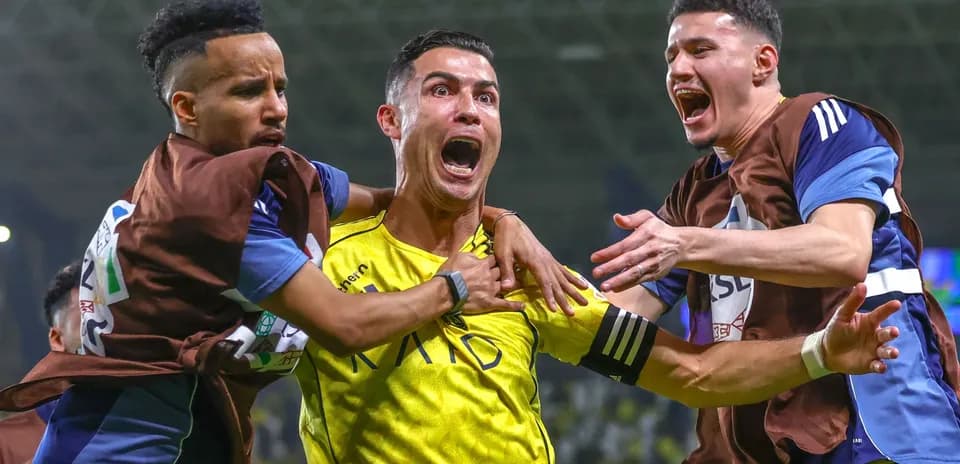 Three players celebrating a goal on the field