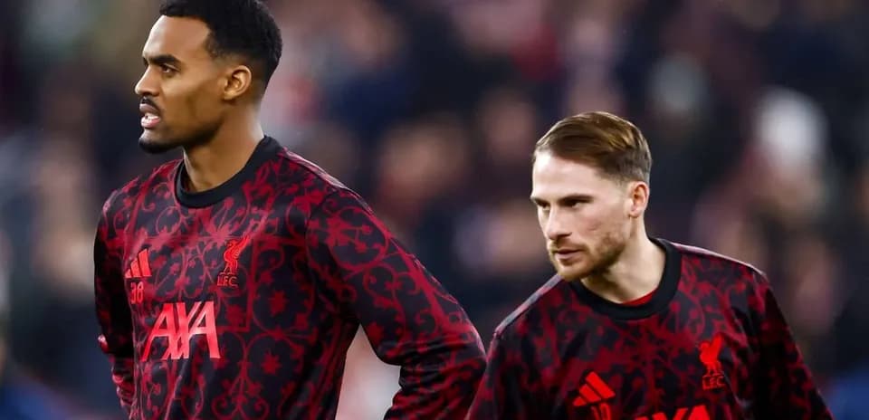 Two Liverpool players in training kits on pitch