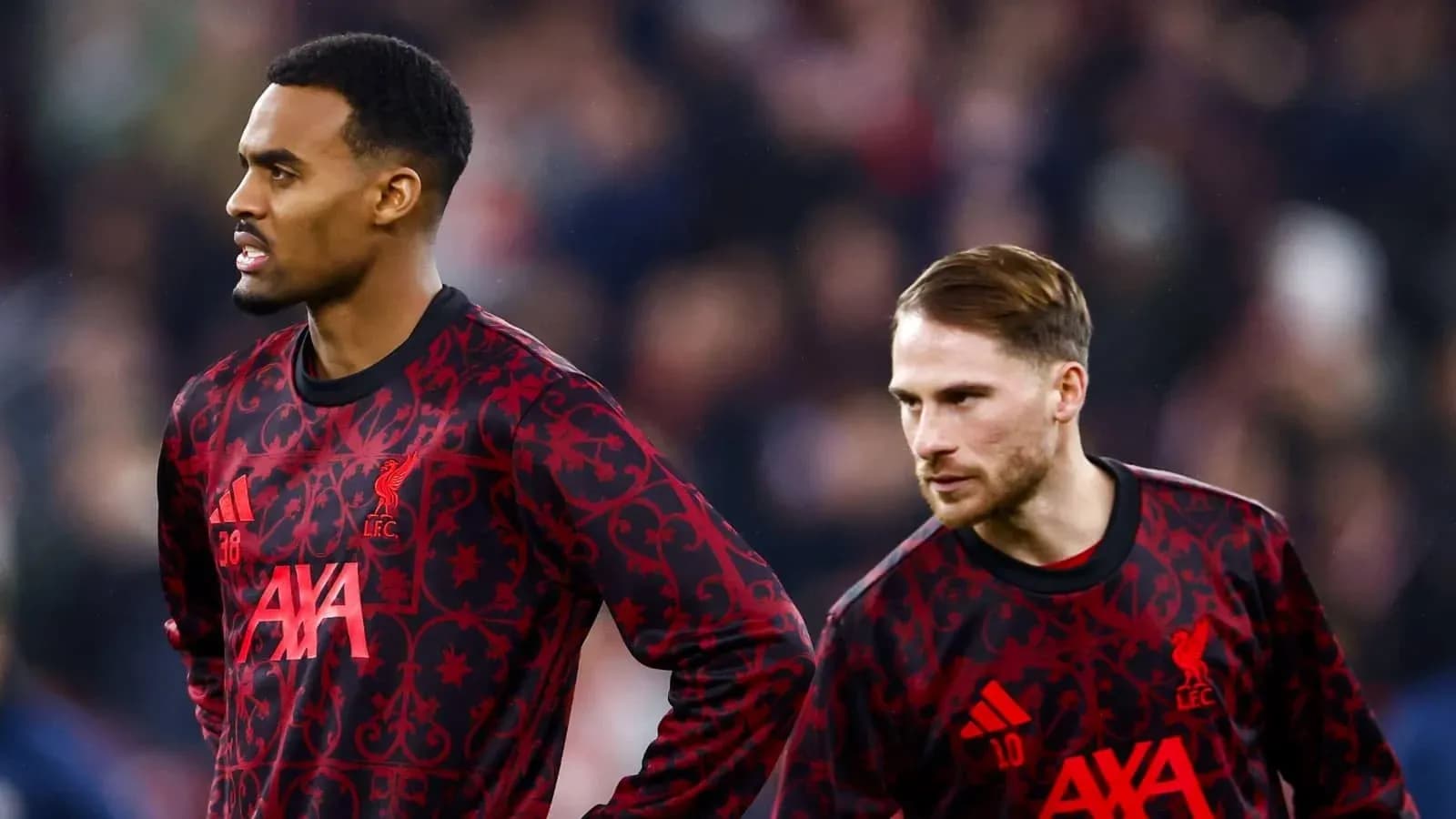 Two Liverpool players in training kits on pitch