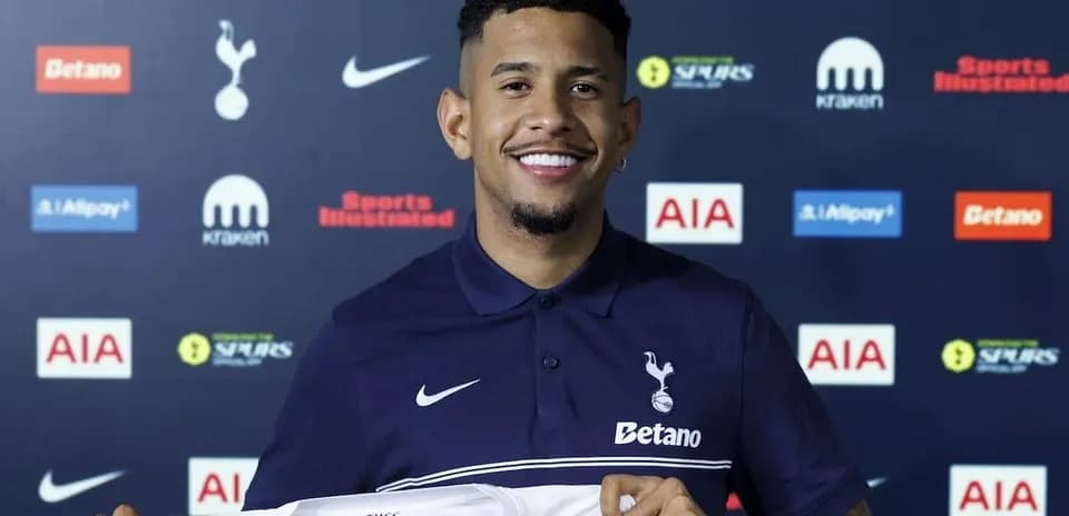 Player holding Tottenham Hotspur jersey at presentation
