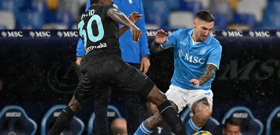 Napoli player challenging Lazio opponent for the ball