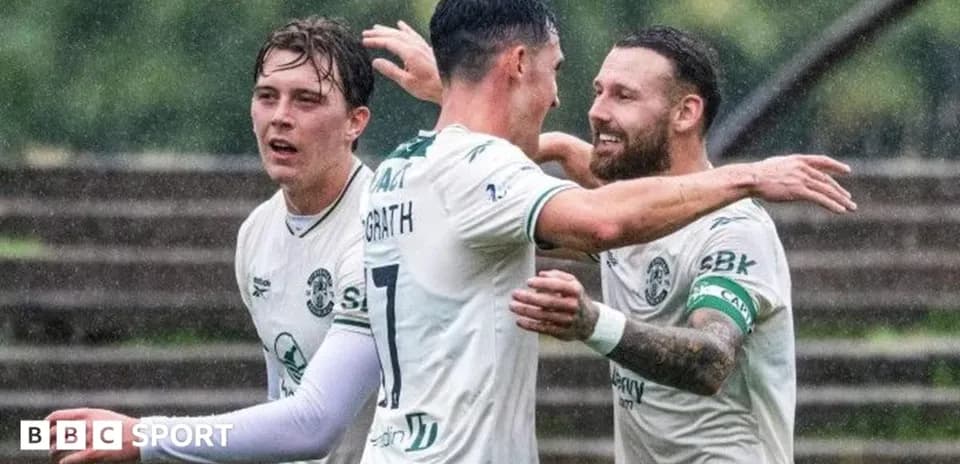 Hibernian players celebrating a goal in the rain