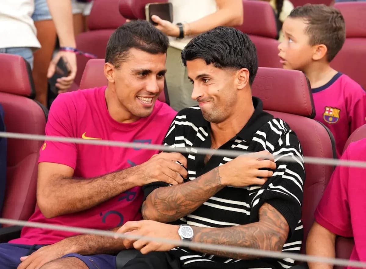 Two football players seated, smiling and interacting