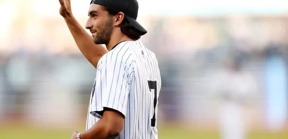 Man in baseball jersey waving at the crowd