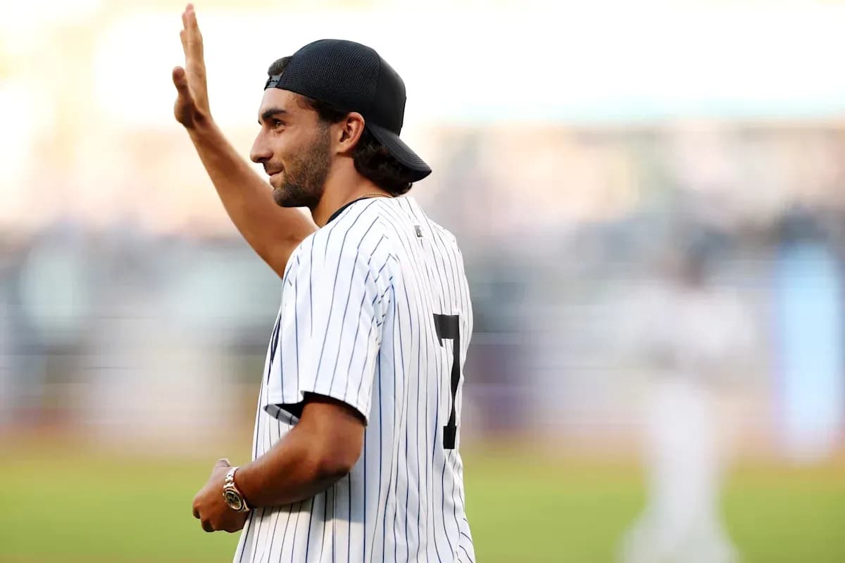 Man in baseball jersey waving at the crowd