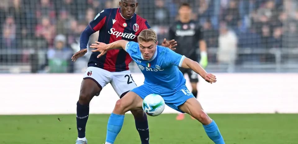 Napoli player challenging Bologna defender for ball