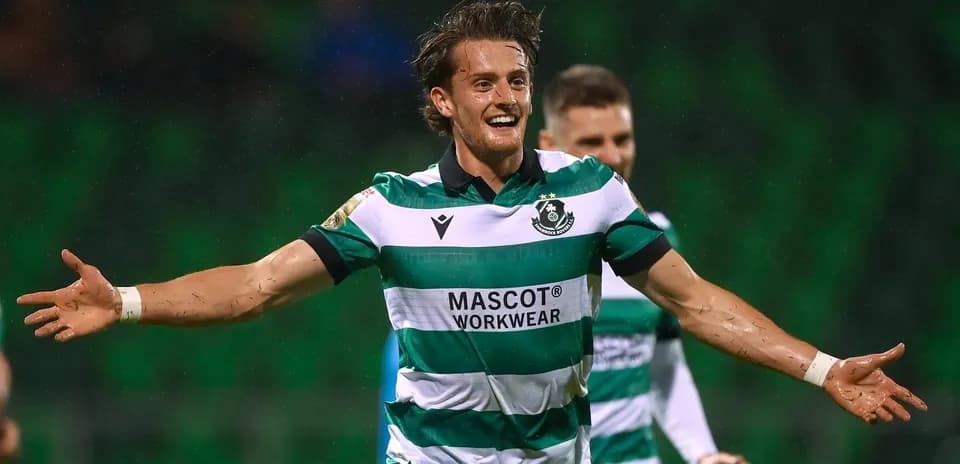 Player celebrating a goal in a green striped jersey
