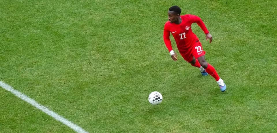 Canadian player dribbling the ball on field