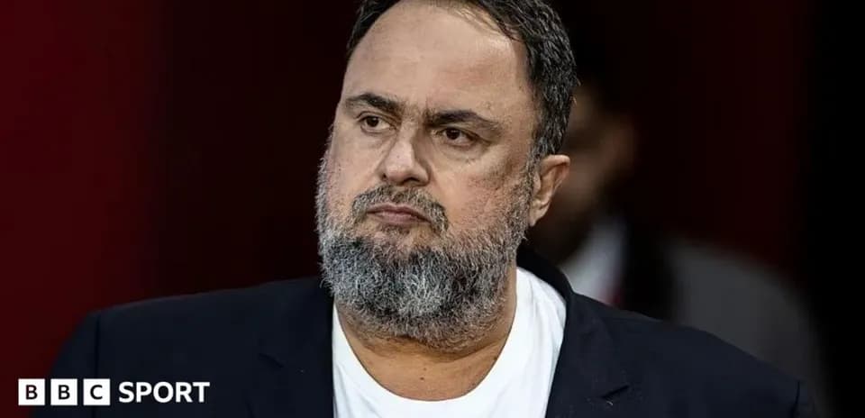 Man in suit with beard during press event
