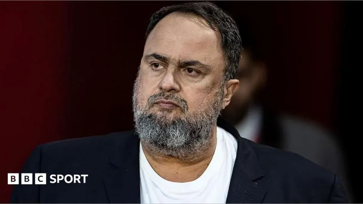 Man in suit with beard during press event