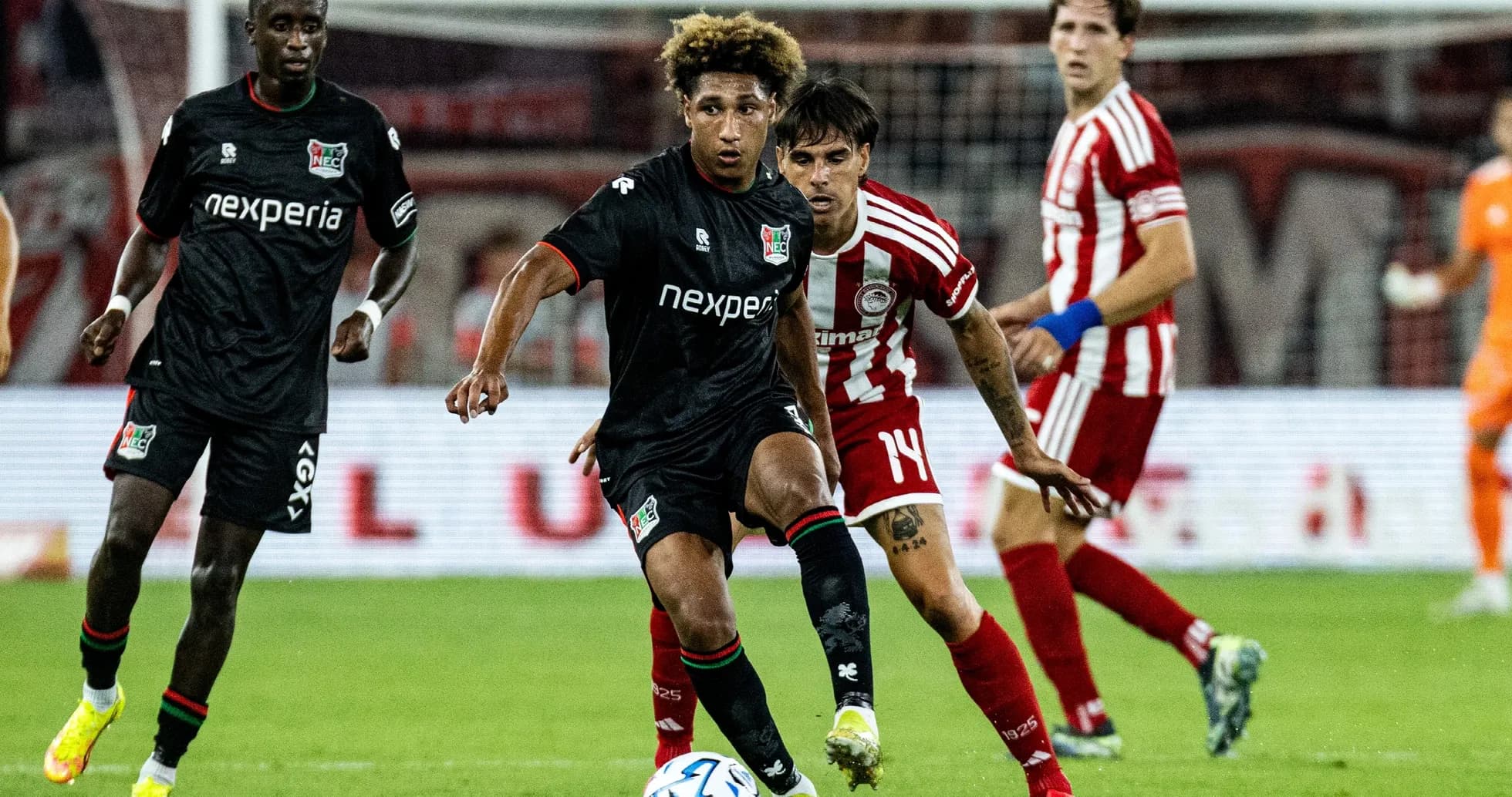 NEC player dribbling past Olympiakos defenders