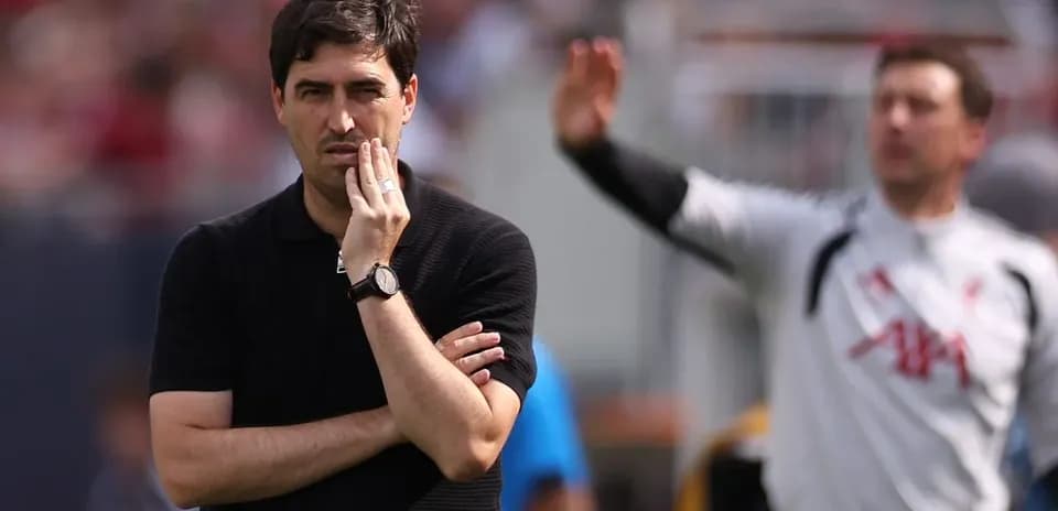 Coach observing match while player gestures behind