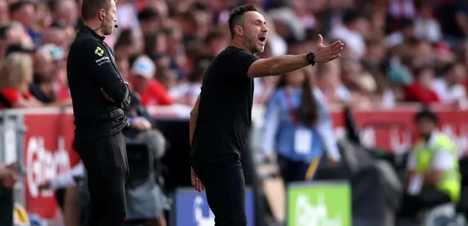 Coach gesturing during a football match on sidelines