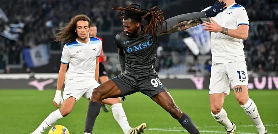Napoli player challenging Lazio defenders for the ball