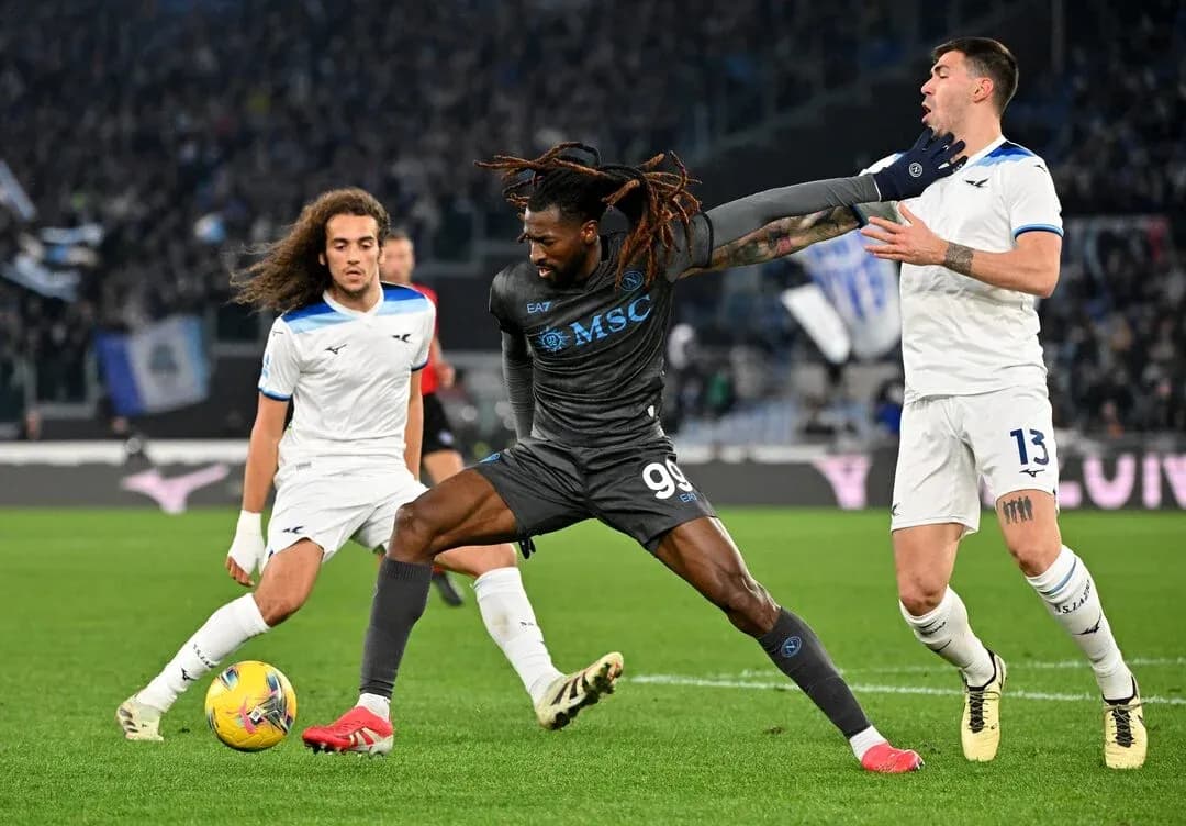 Napoli player challenging Lazio defenders for the ball