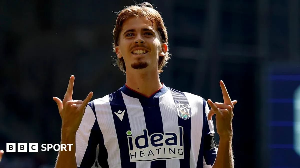 Player celebrating with hand gestures in team jersey