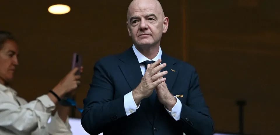 FIFA official applauding in a stadium box
