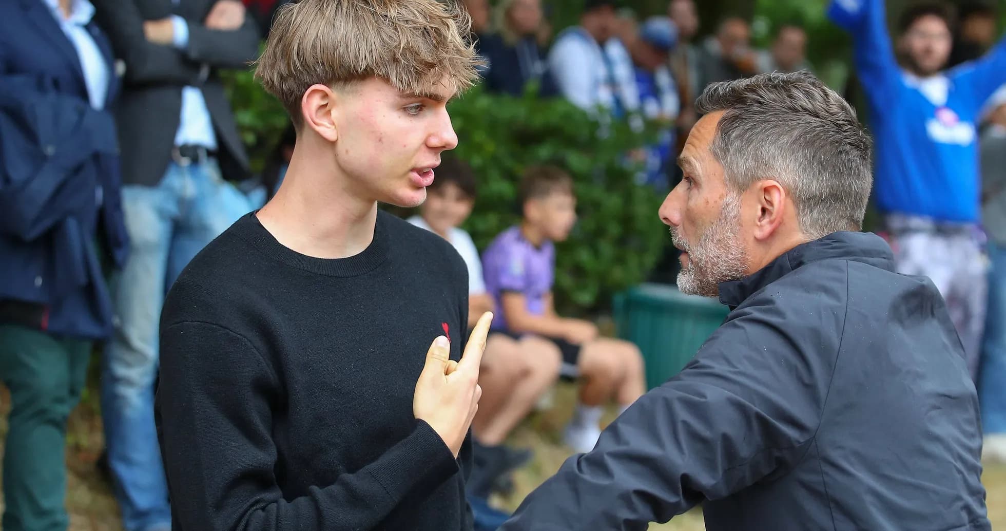 Two individuals discussing intensely near spectators
