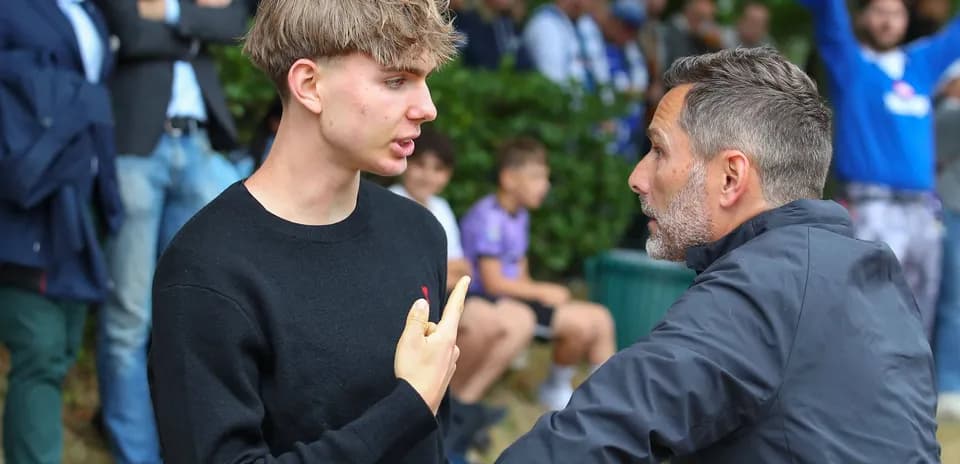 Two individuals discussing intensely near spectators