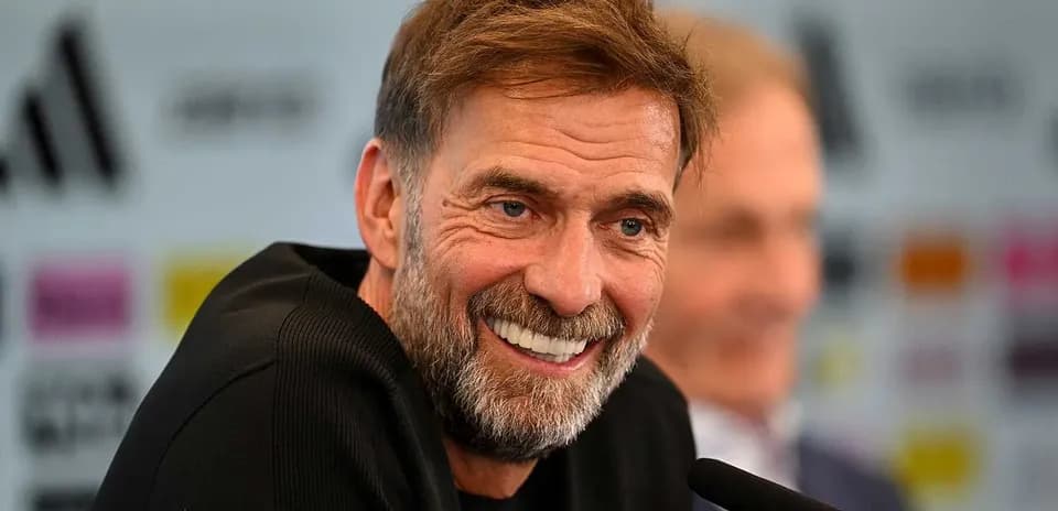 Manager smiling during press conference at podium