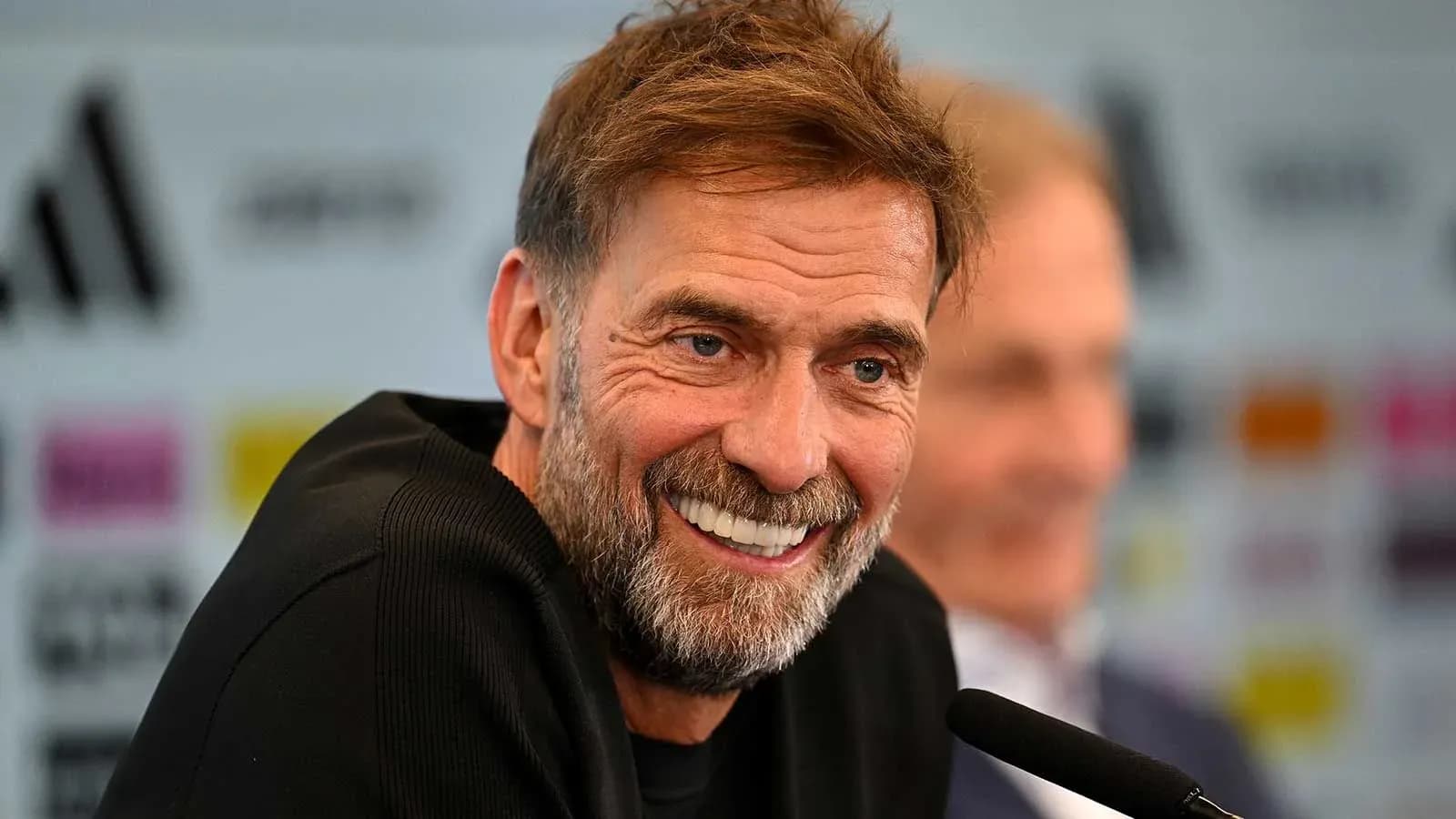 Manager smiling during press conference at podium
