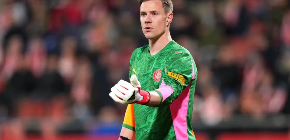 Goalkeeper in green kit signaling during match
