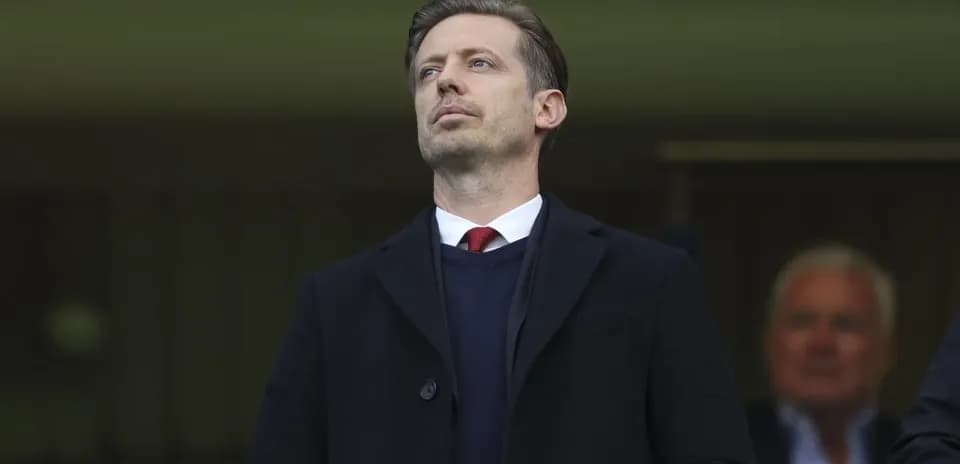Man in formal attire observing from the stands