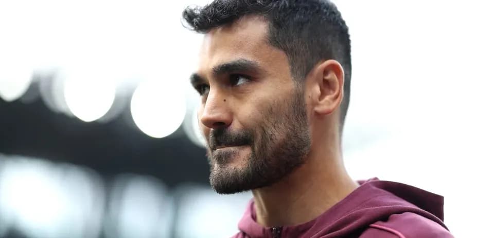 Player in maroon hoodie during pre-match preparation