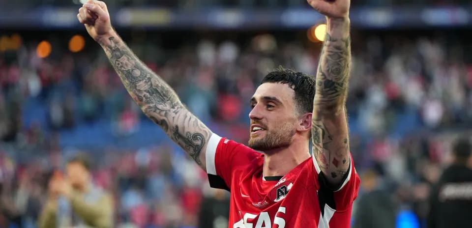 Player celebrating with raised arms in red jersey