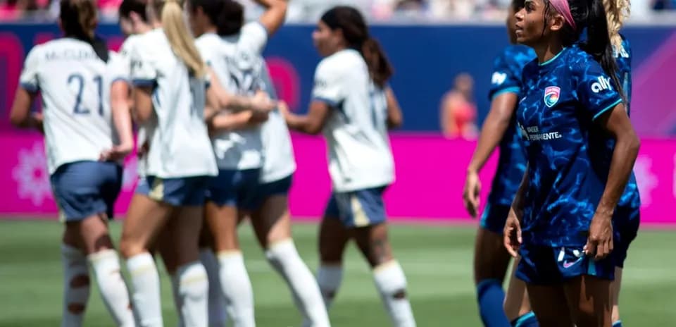 Players celebrating a goal during NWSL match