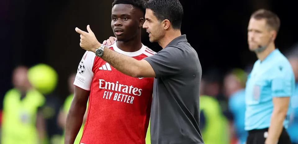 Manager speaking to player during match on sidelines