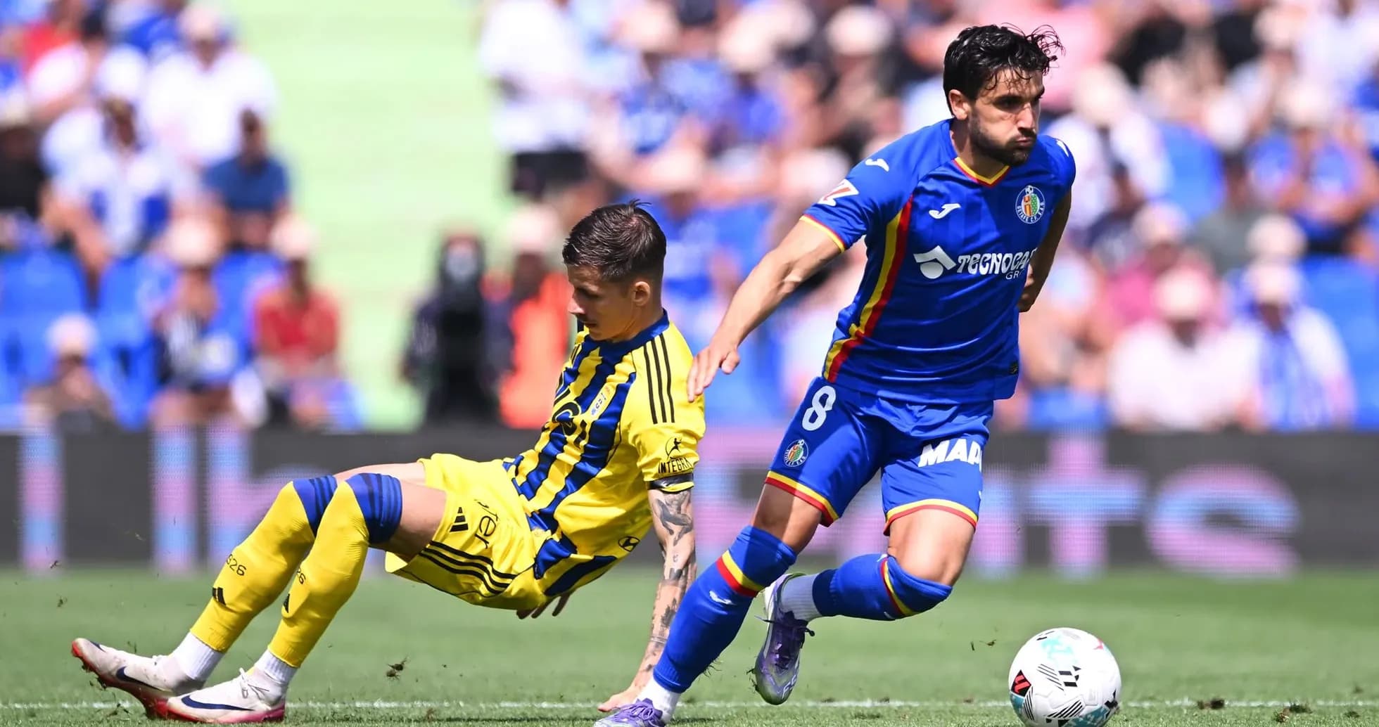Player from Getafe tackling Oviedo player