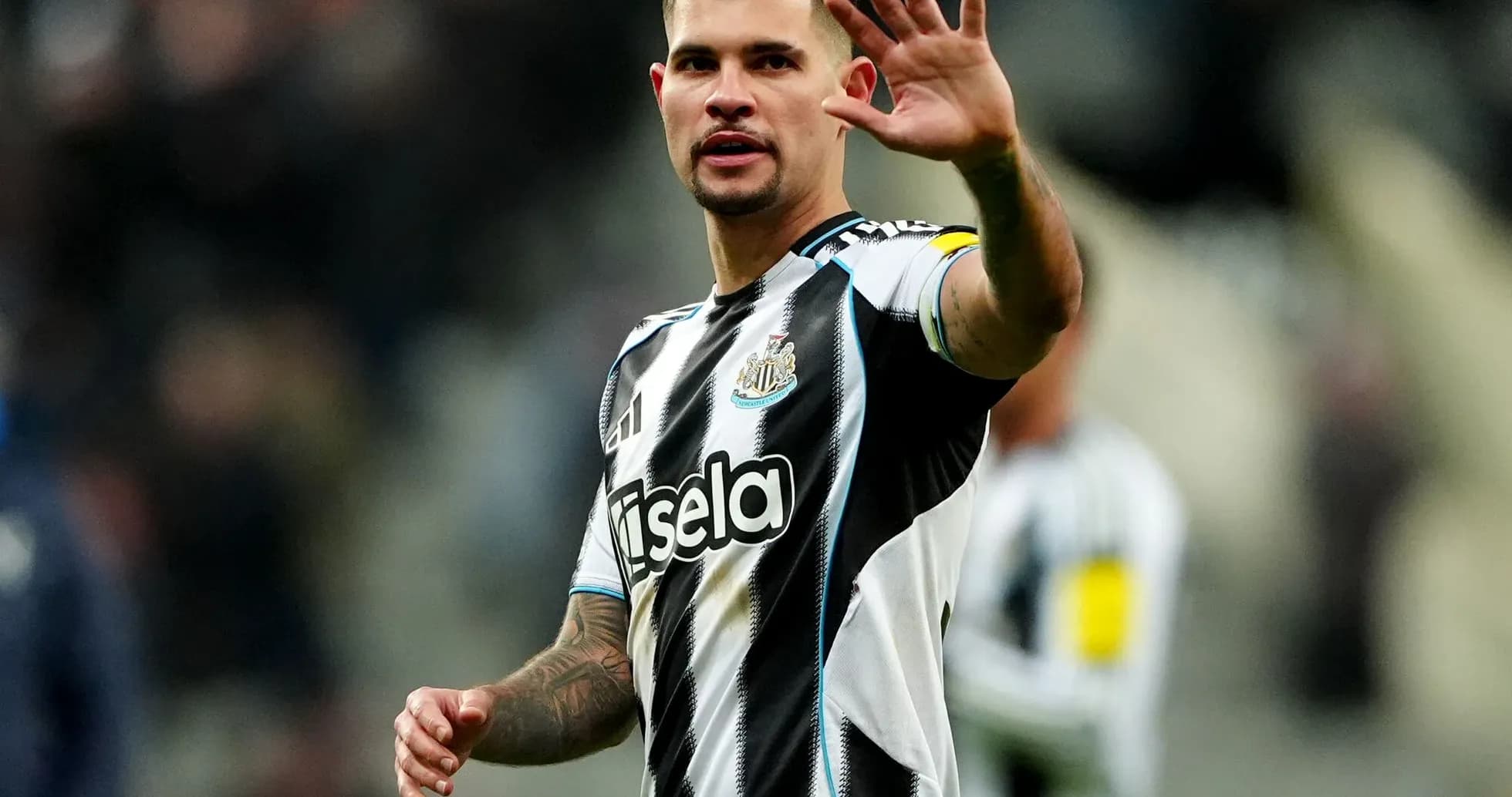 Player waving to fans during match at St James' Park